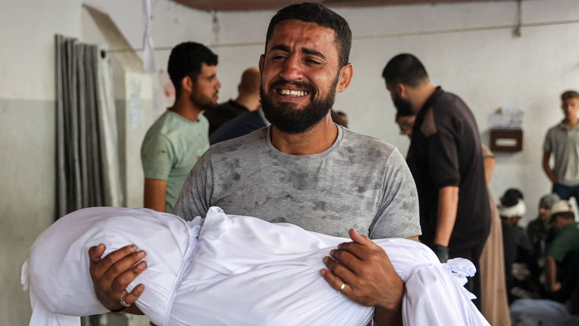 فلسطيني يحمل طفله الشهيد في غزة