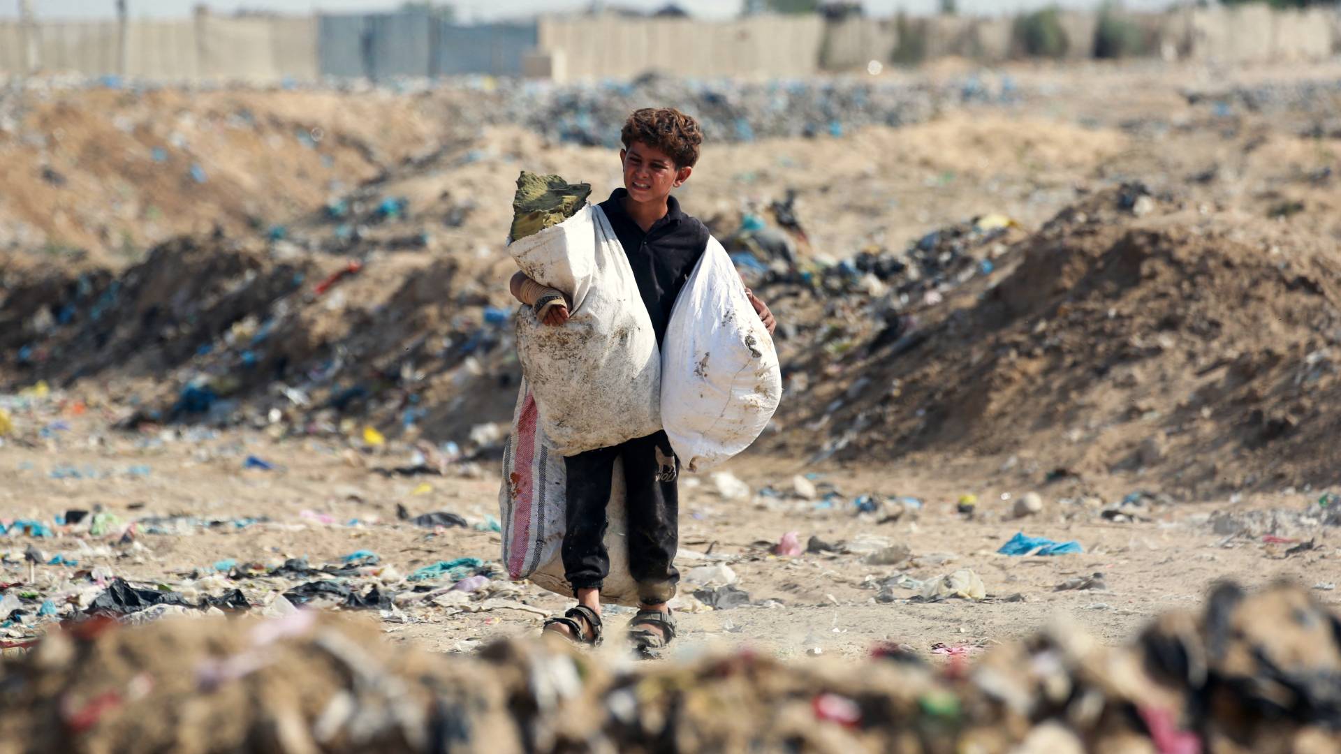 طفل فلسطيني يجمع ما يحتاجه من النفايات