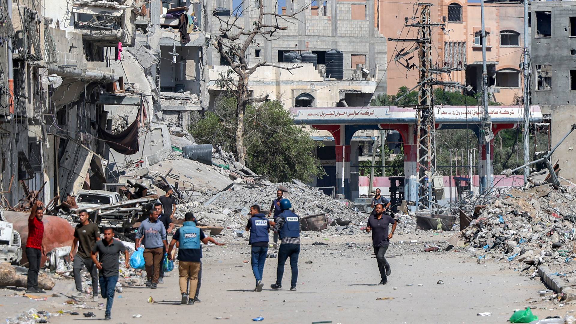 فلسطينيون أمام مبانٍ مدمرة في مخيم جباليا شمال غزة