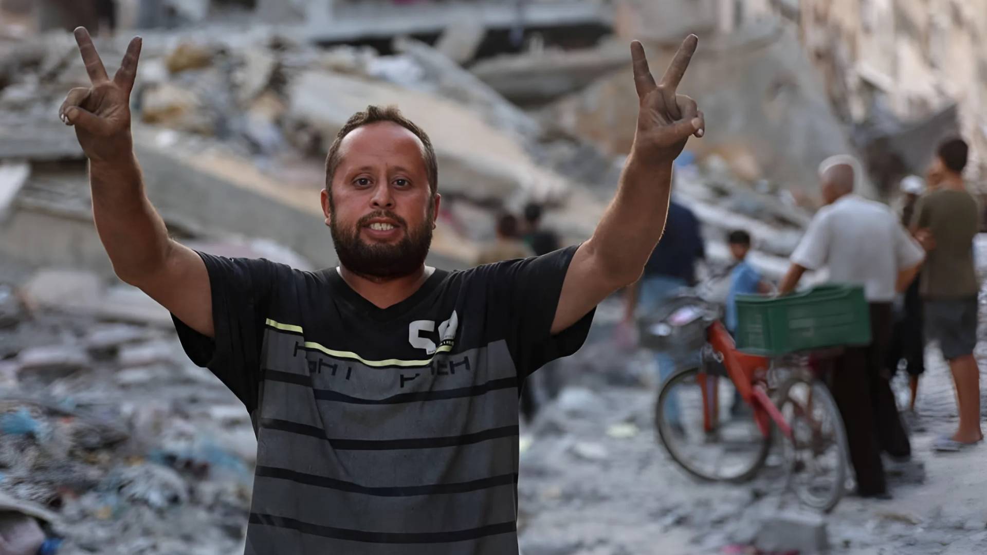 فلسطيني يرفع إشارة الصر بين الركام في غزة
