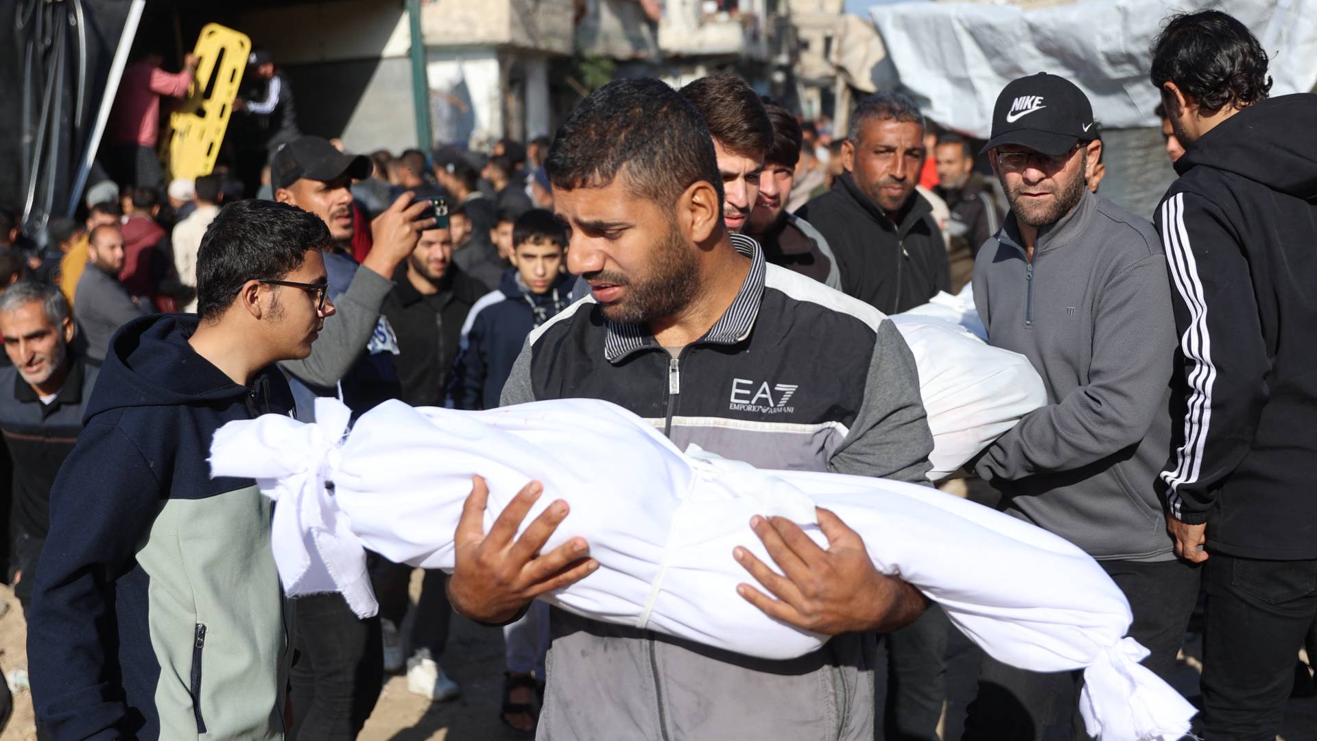 فلسطيني يحمل جثمان طفله الشهيد