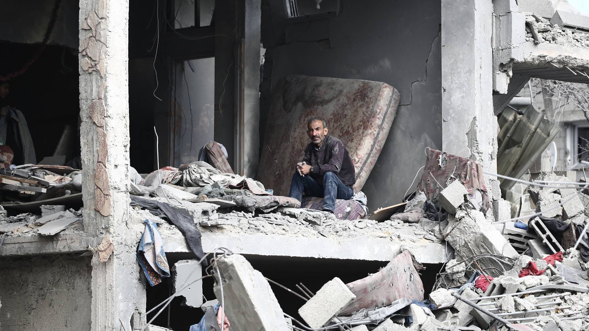 فلسطيني يجلس في منزله الذي تعرض للقصف في غزة