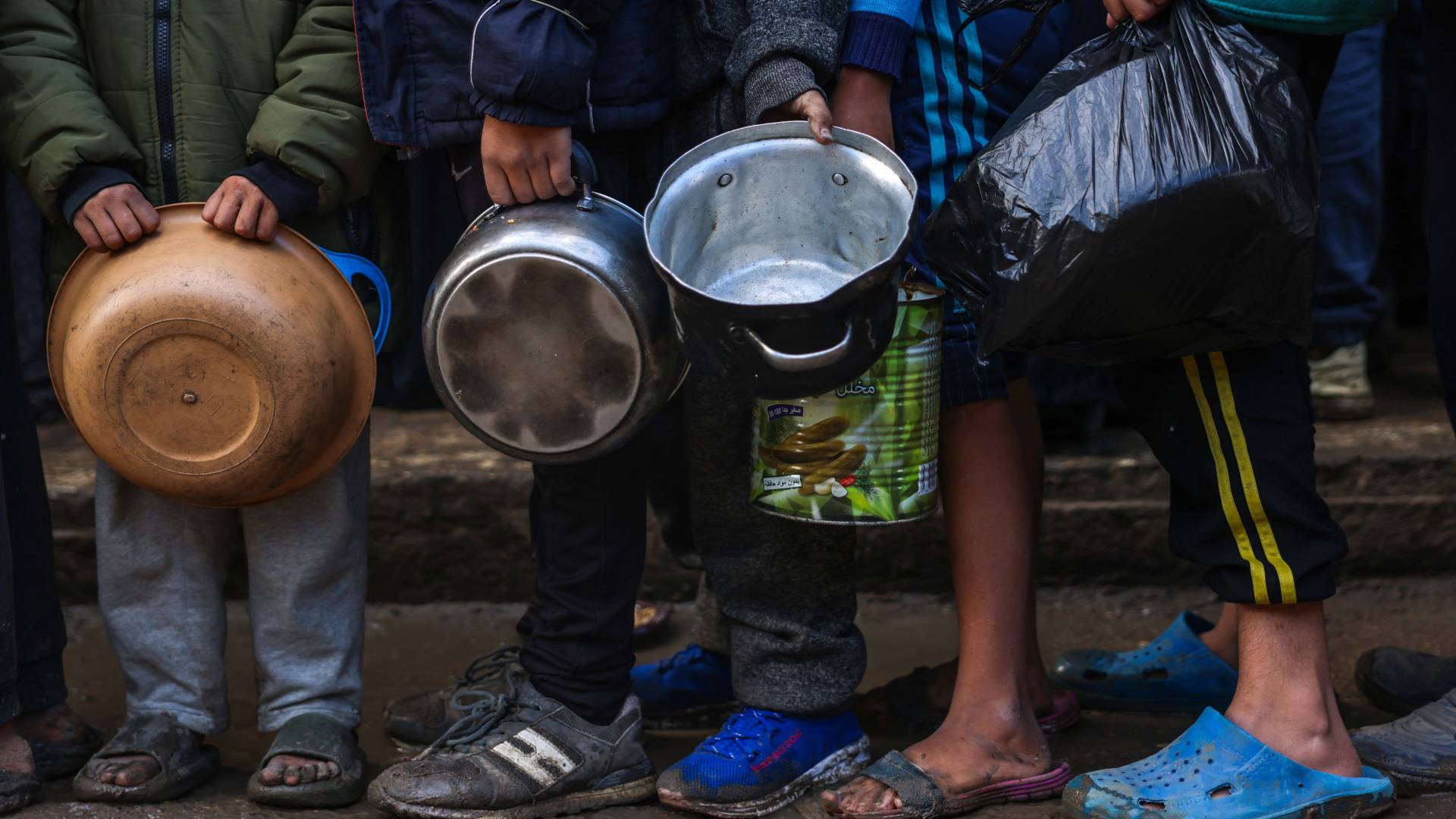 أطفال في قطاع غزة يحملون أوعية للبحث عن طعام