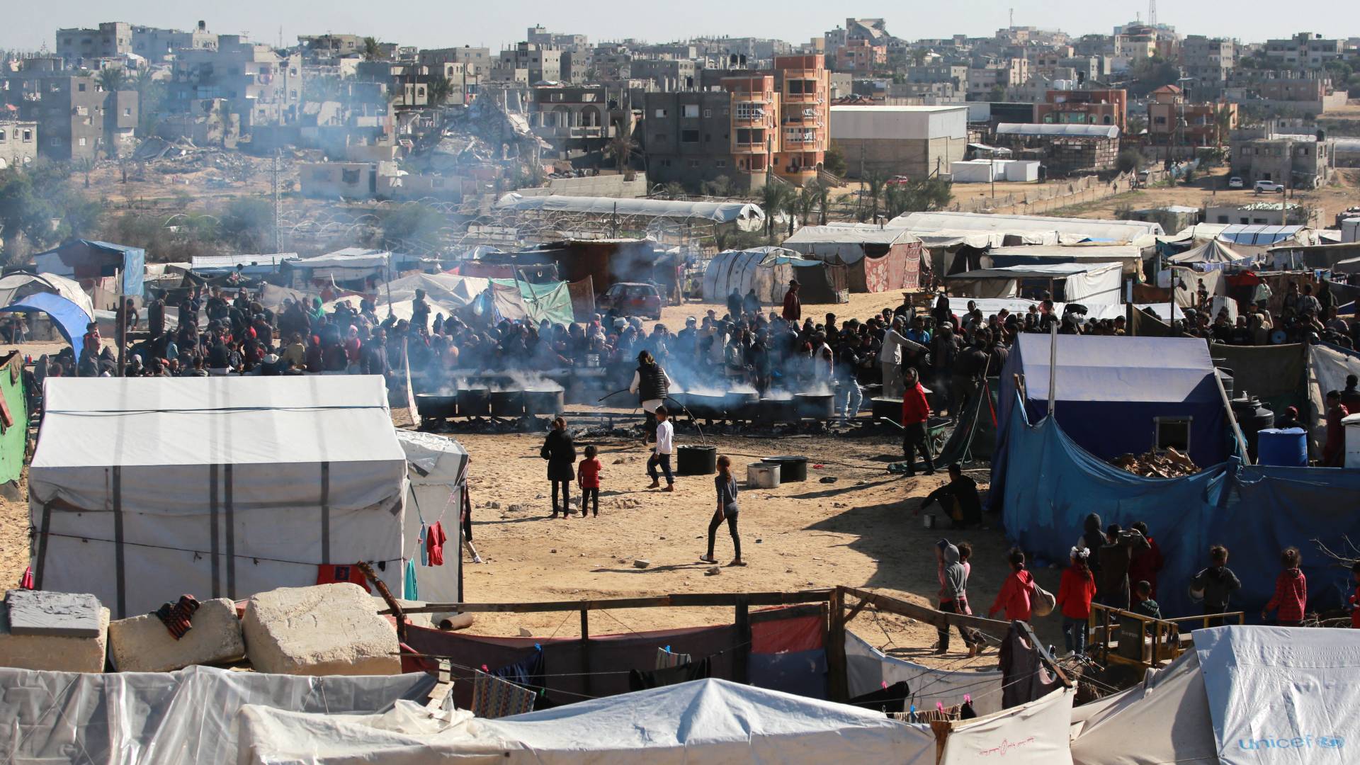 فلسطينيون ينتظرون الحصول على حصة غذائية في مركز توزيع جنوب خان يونس