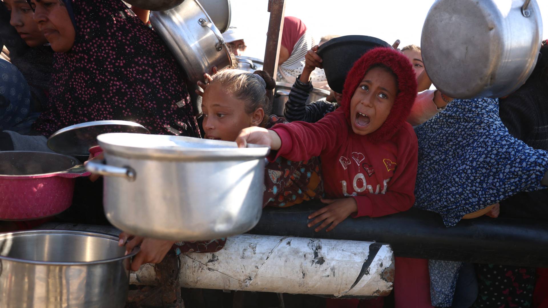 يقف فلسطينيون في انتظار حصة طعام في مركز توزيع جنوب خان يونس