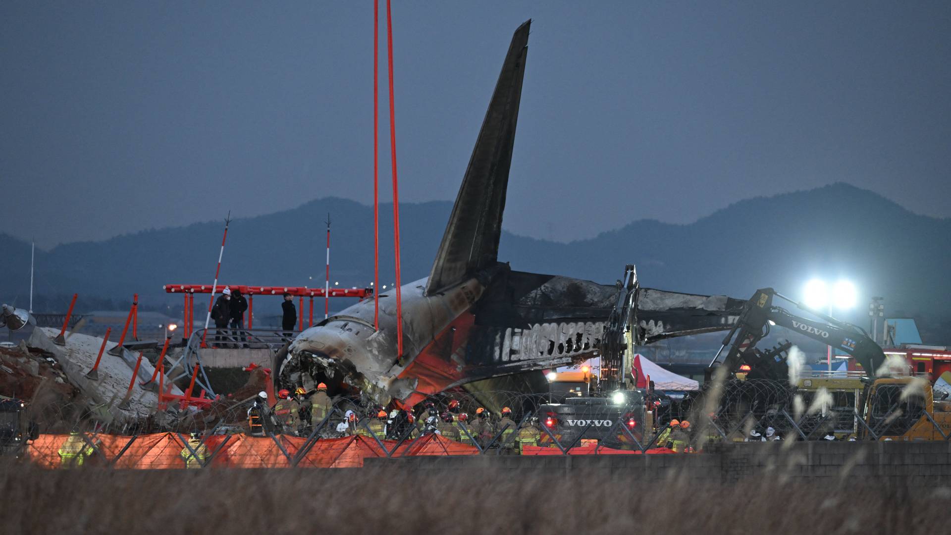 يعمل رجال الإطفاء وأفراد الإنقاذ بالقرب من مكان تحطم طائرة بوينج 737-800 التابعة لشركة طيران جيجو