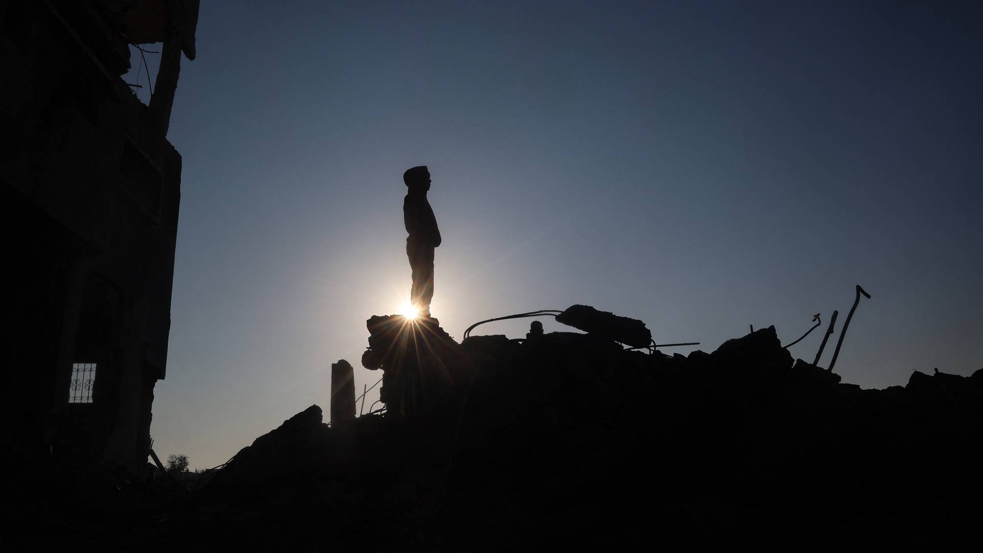 فلسطيني يقف فوق ركام منزله في قطاع غزة