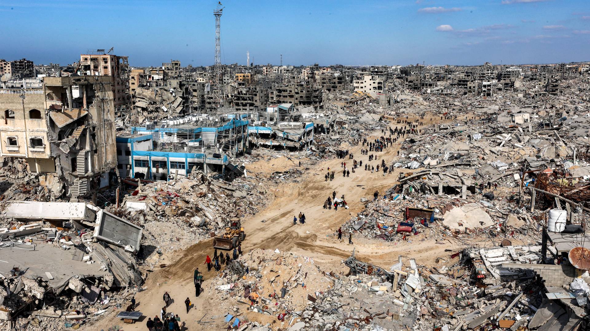 يمشي الناس بين أنقاض المباني المنهارة في قطاع غزة