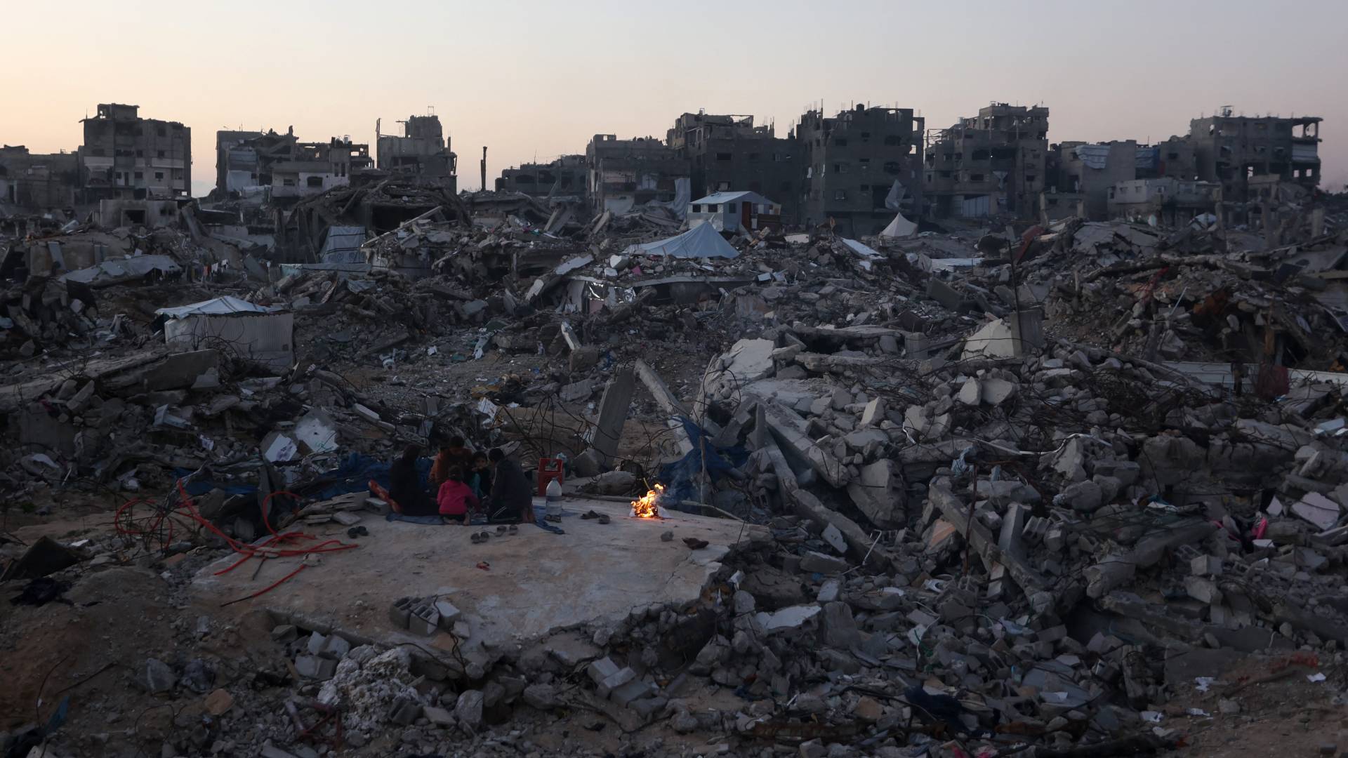 عائلة فلسطينية تجلس على أنقاض منزلها أثناء إفطارها في جباليا شمال قطاع غزة