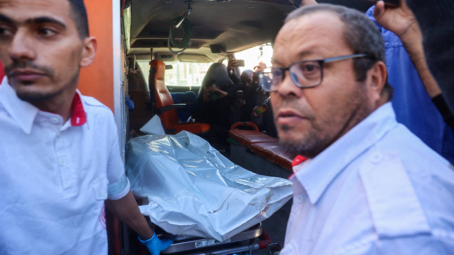 نقل جثمان موظف في الأمم المتحدة داخل سيارة إسعاف بمستشفى شهداء الأقصى بمدينة دير البلح وسط القطاع