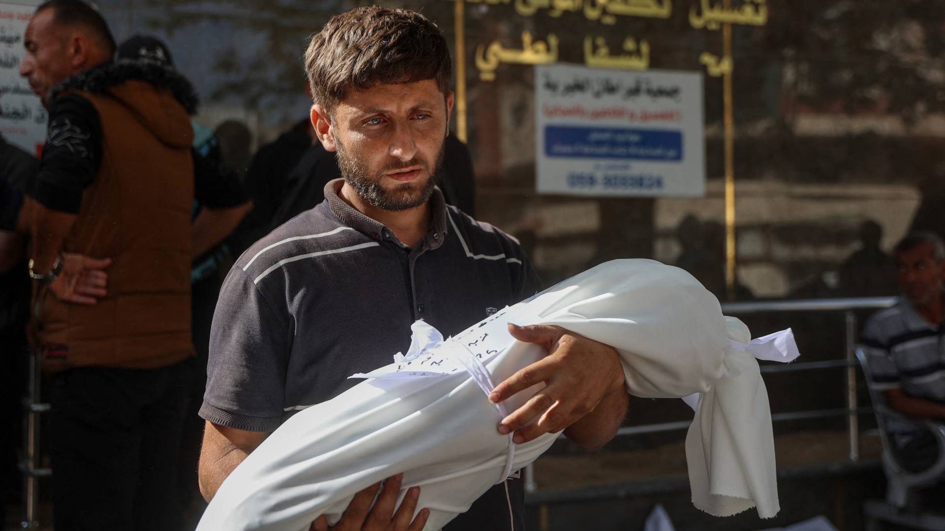 أب يحمل جثمان طفله الصغير في غزة