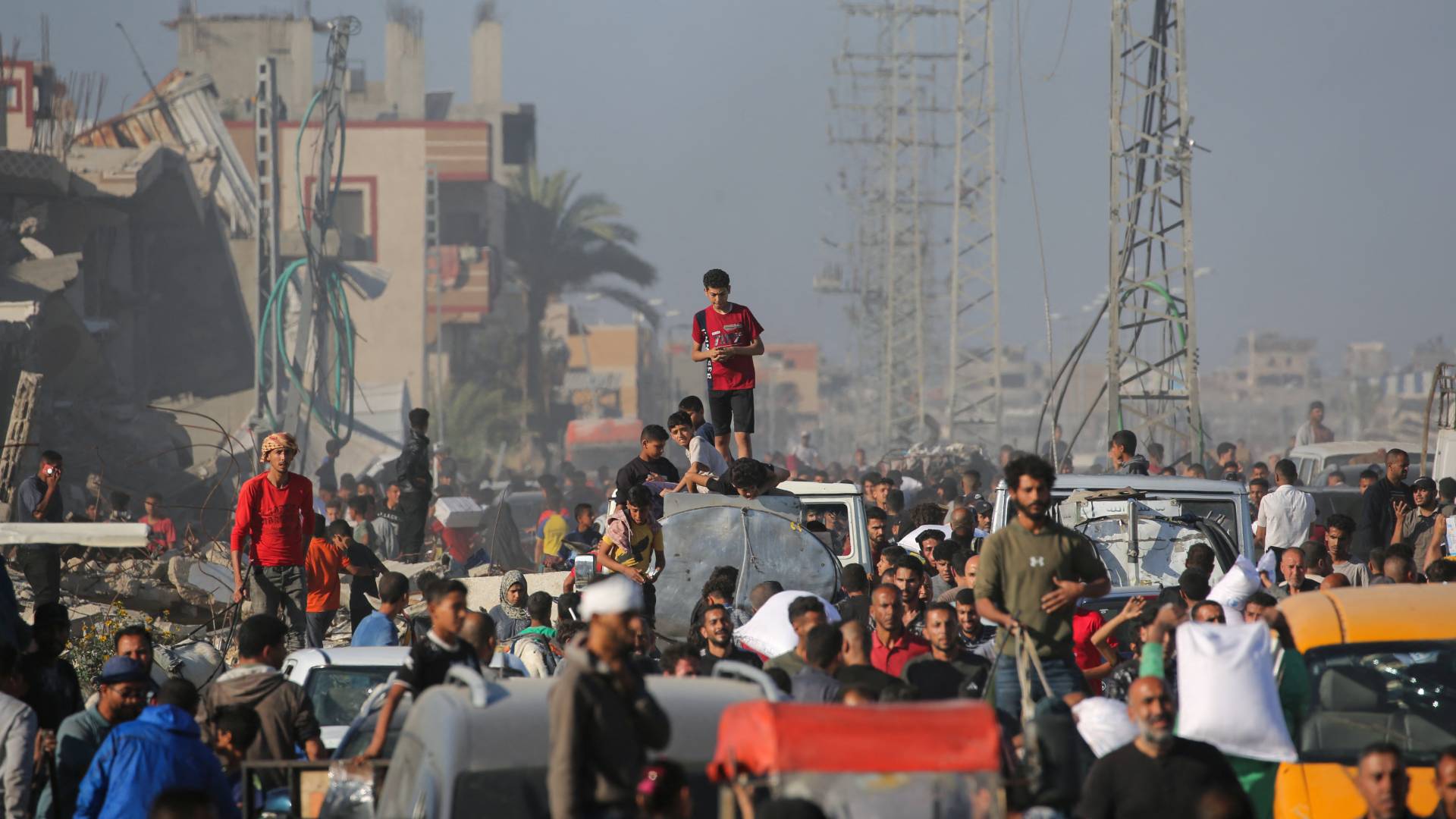 نازحون فلسطينيون ينقلون أكياسا من المساعدات الغذائية