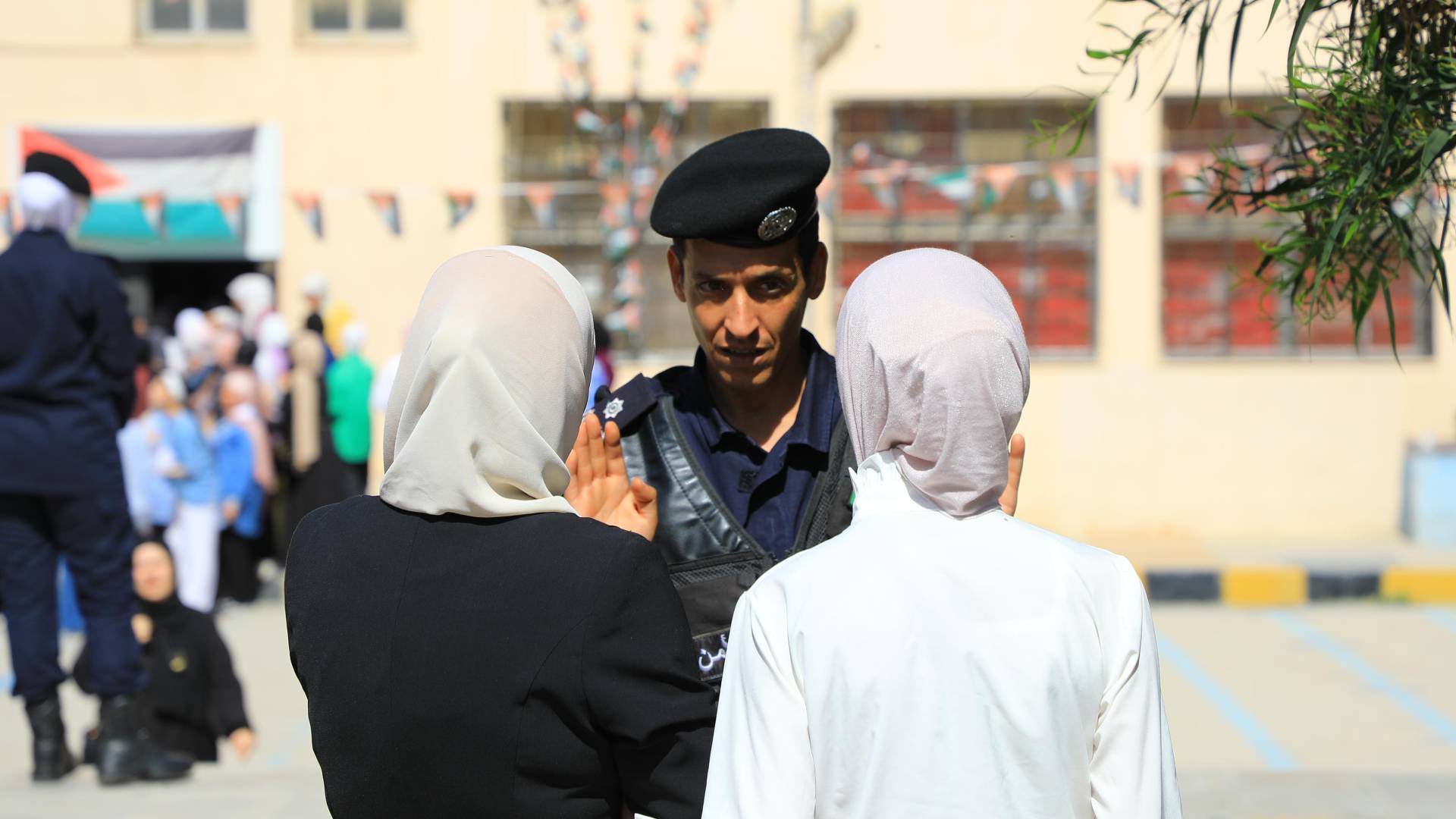 رجل أمن عند بوابة مدرسة قبيل تقديم امتحان التوجيهي