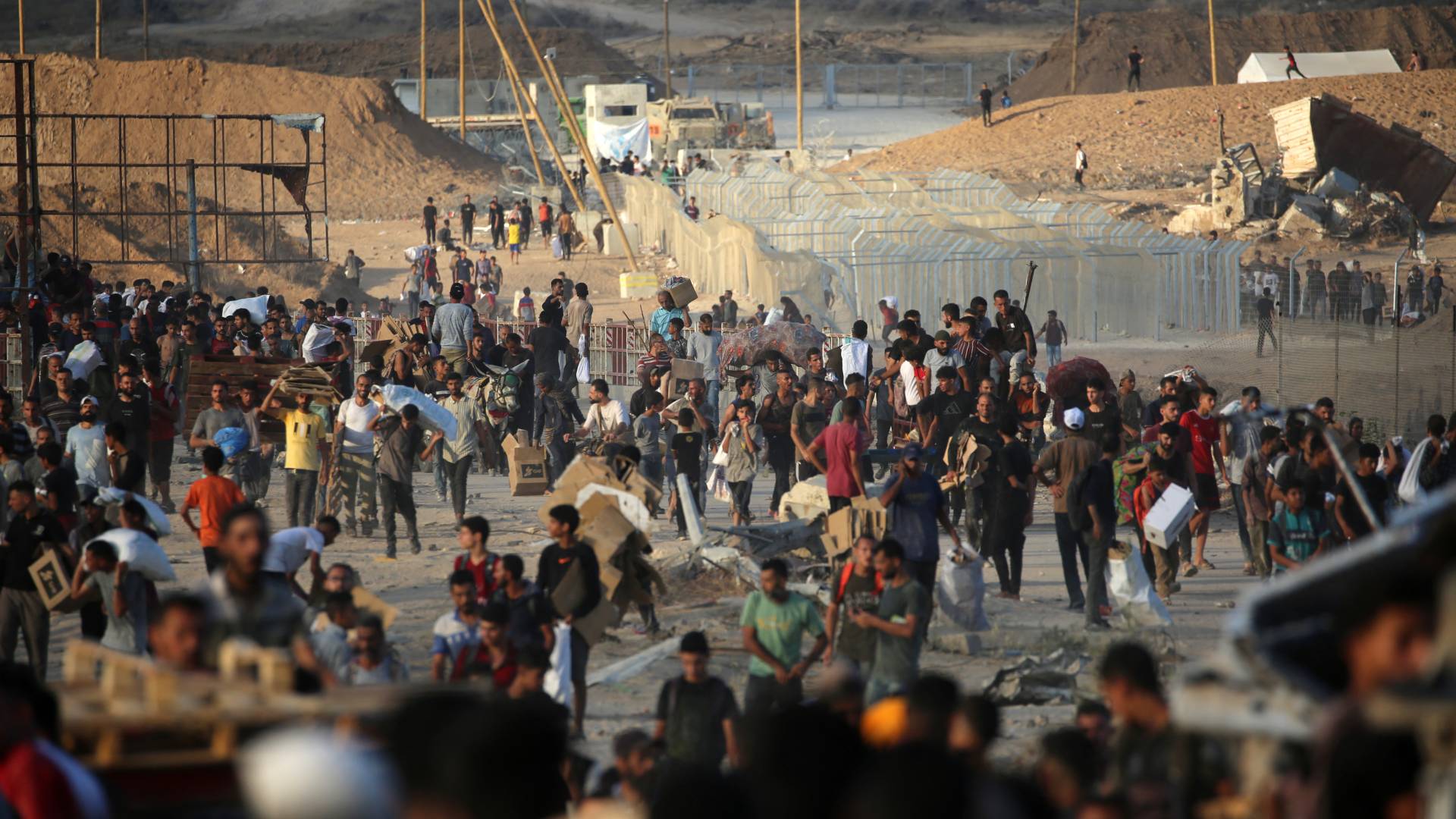 فلسطينيون عند نقطة توزيع مساعدات بالقرب من مخيم النصيرات وسط قطاع غزة