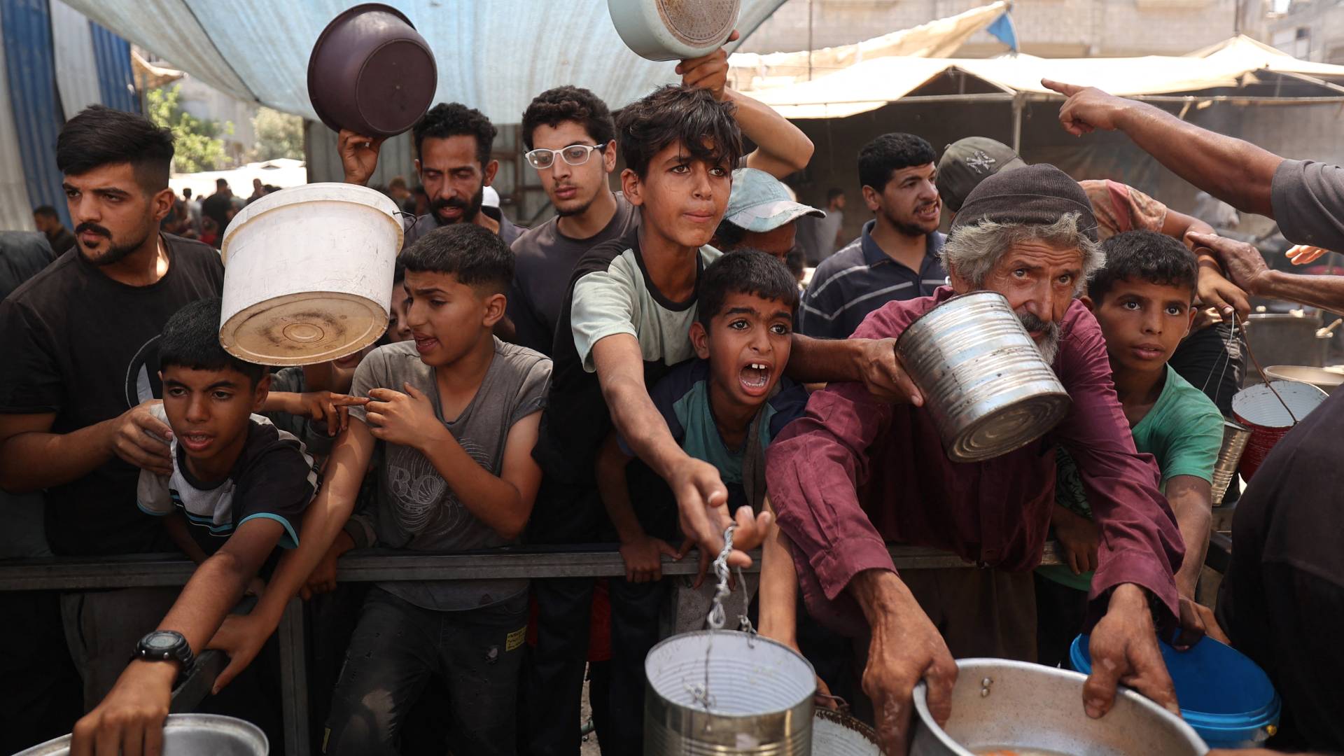 أطفال فلسطينيون يطلبون الغذاء في مخيم النصيرات وسط قطاع غزة