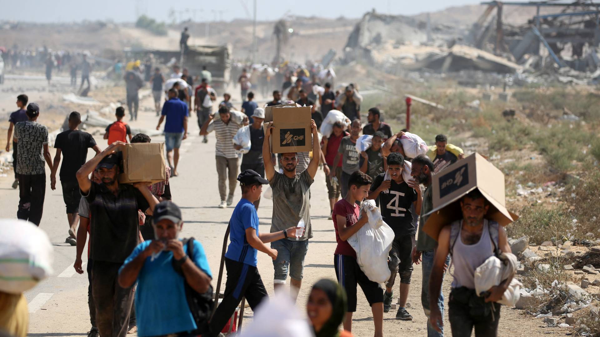 فلسطينيون يتلقون مساعدات في نقطة توزيع الطعام التي تديرها مجموعة "مؤسسة غزة الإنسانية"