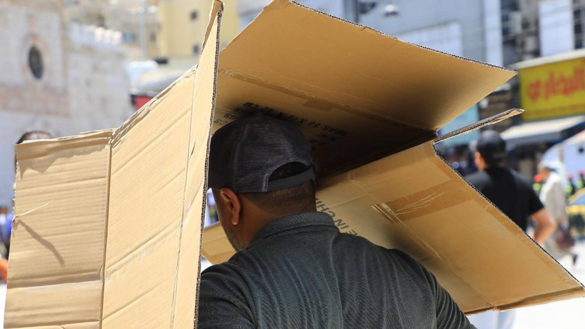 شخص يغطي رأسه بسبب الحرارة العالية