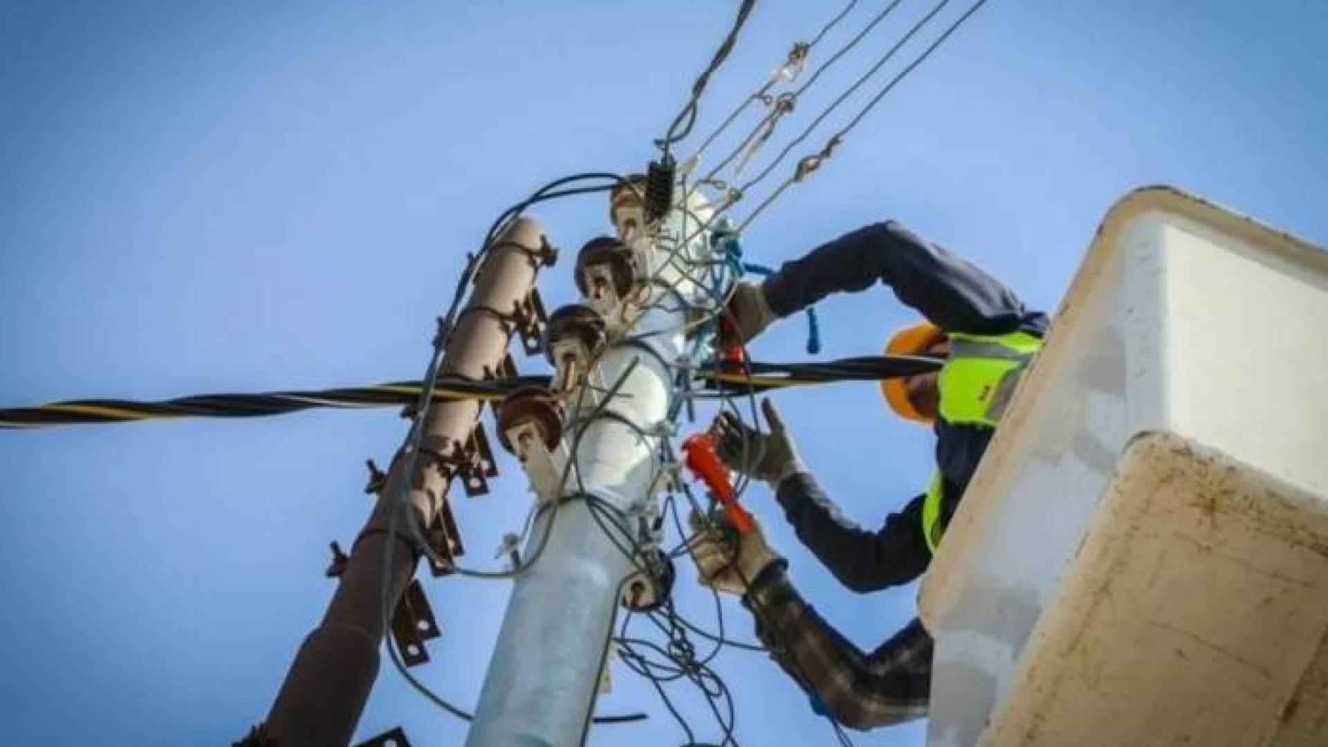 موظف في احدى شركات الكهرباء يجري صيانة دورية للشبكات.. ارشيفية