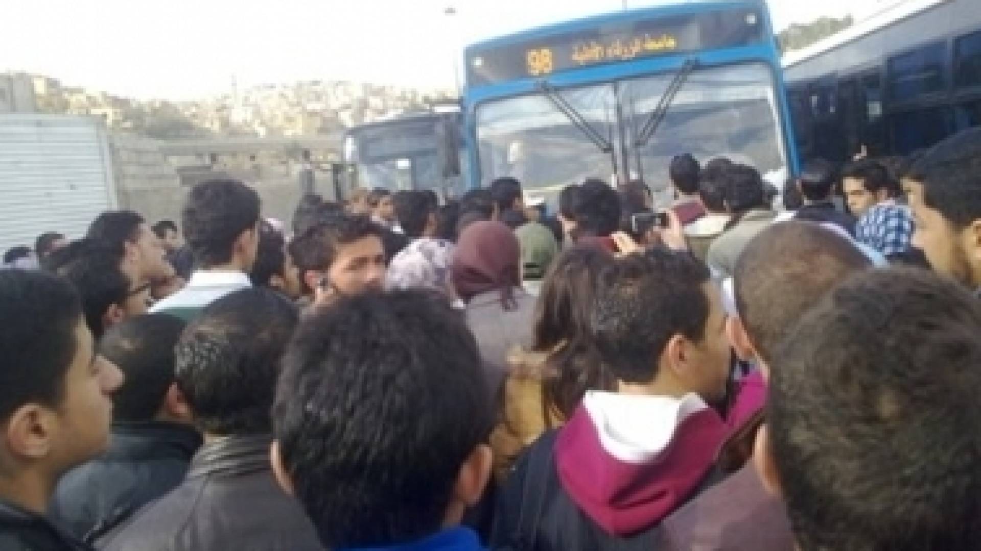 عشرات الطلبة من جامعة آل البيت يحاولون الركوب في الحافلات