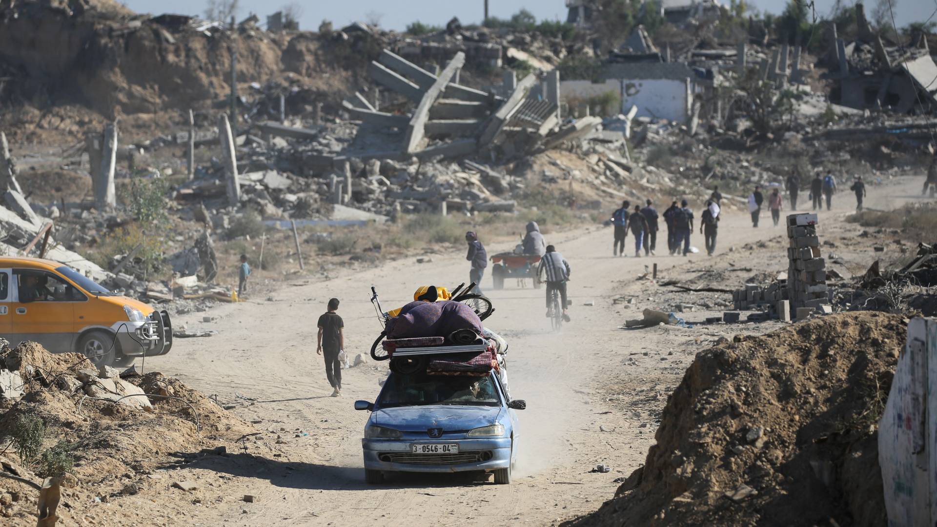 رجل يقود سيارة محمّلة بممتلكاته بينما يعود الفلسطينيون المهجّرون إلى منازلهم في منطقة الزهراء