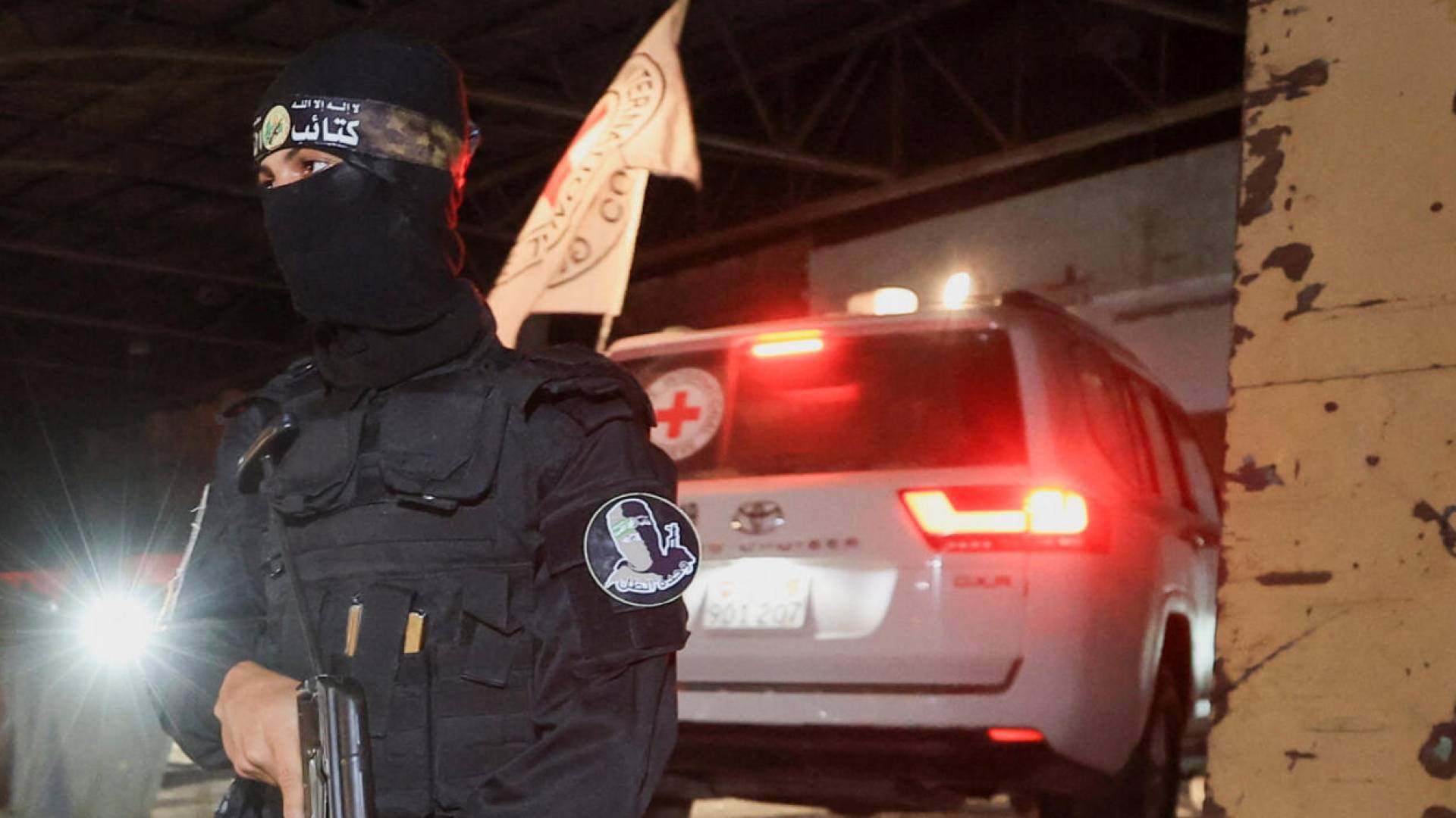 أحد عناصر القسام في قطاع غزة خلفه مركبة للصليب الأحمر الدولي