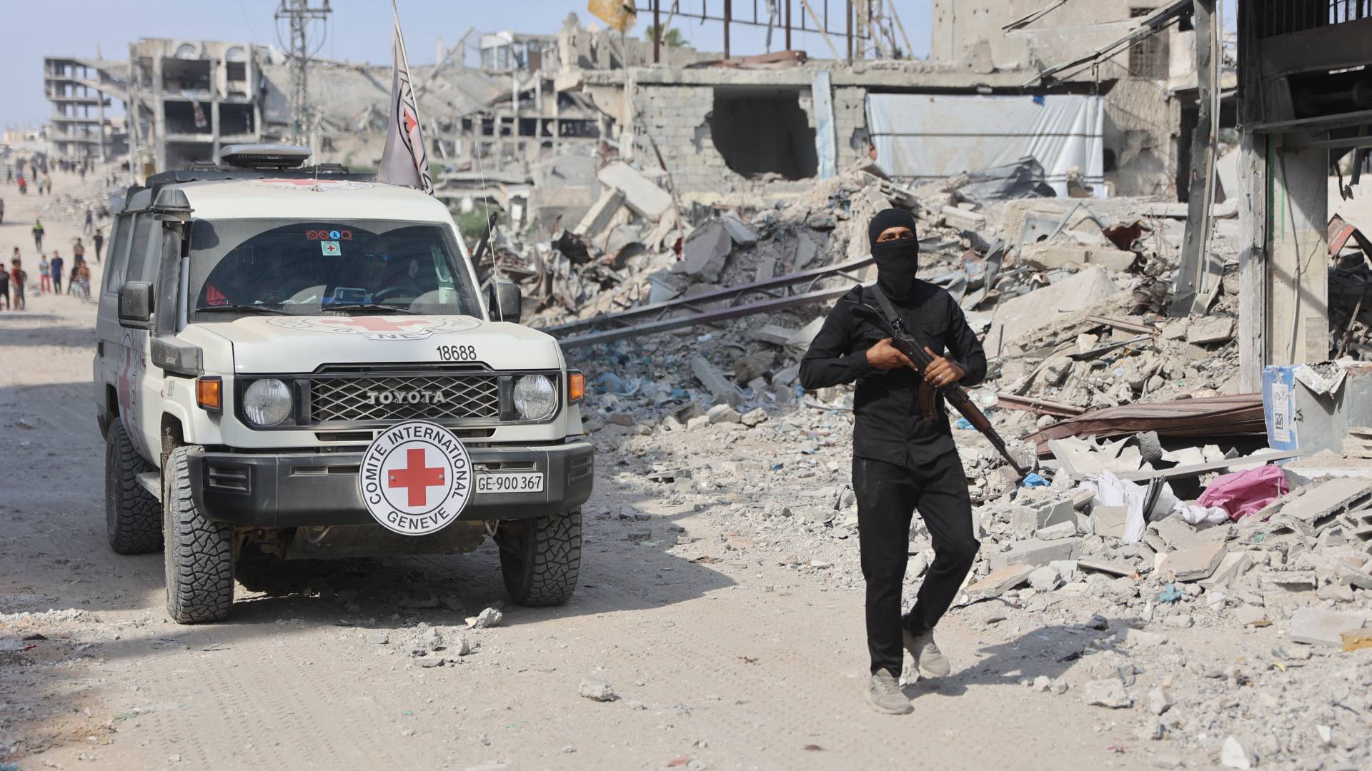 احد عناصر القسام خلفه مركبة للصليب الأحمر