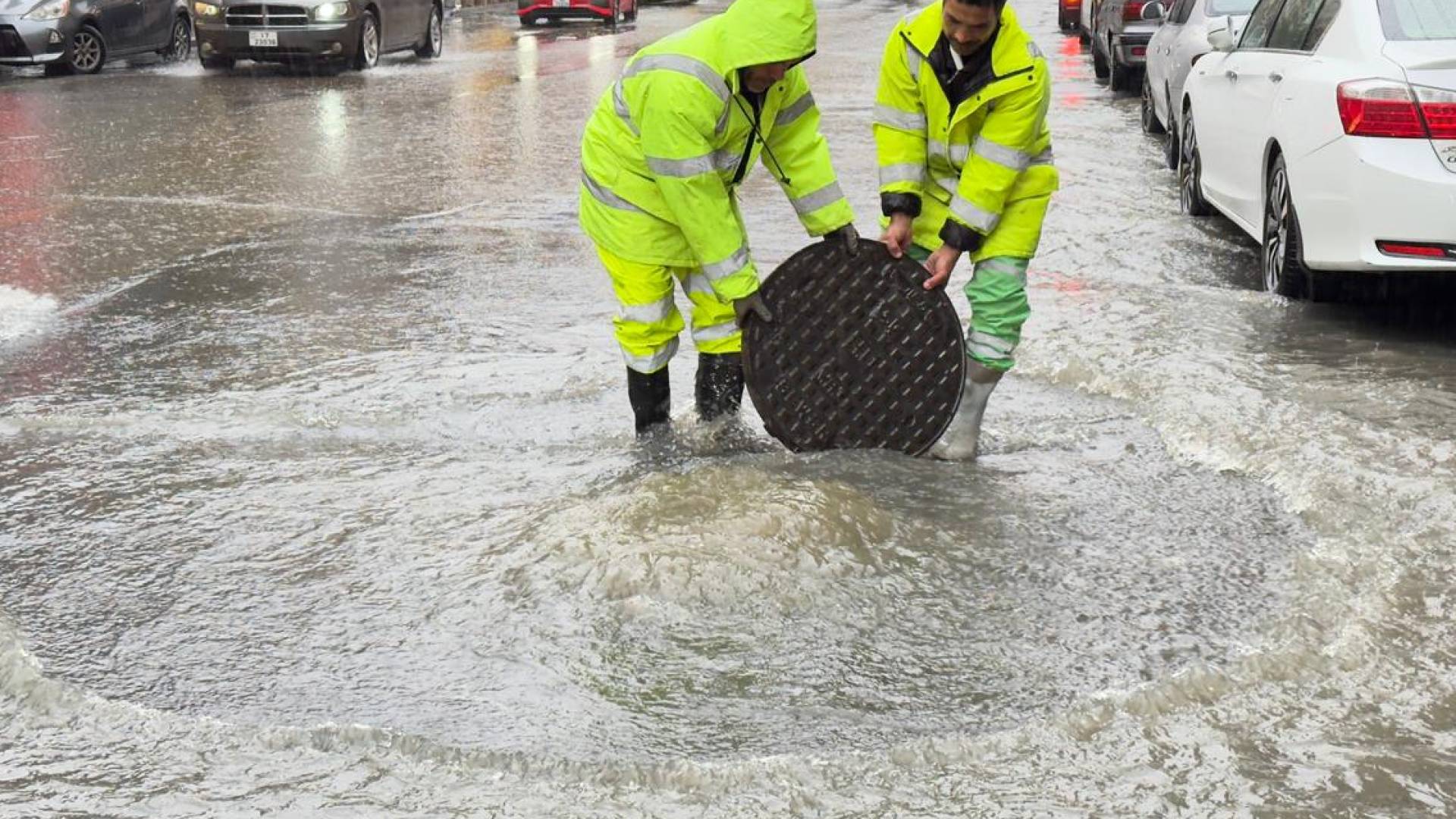عمال وطن يعملون على فتح منهل لتصريف مياه الأمطار