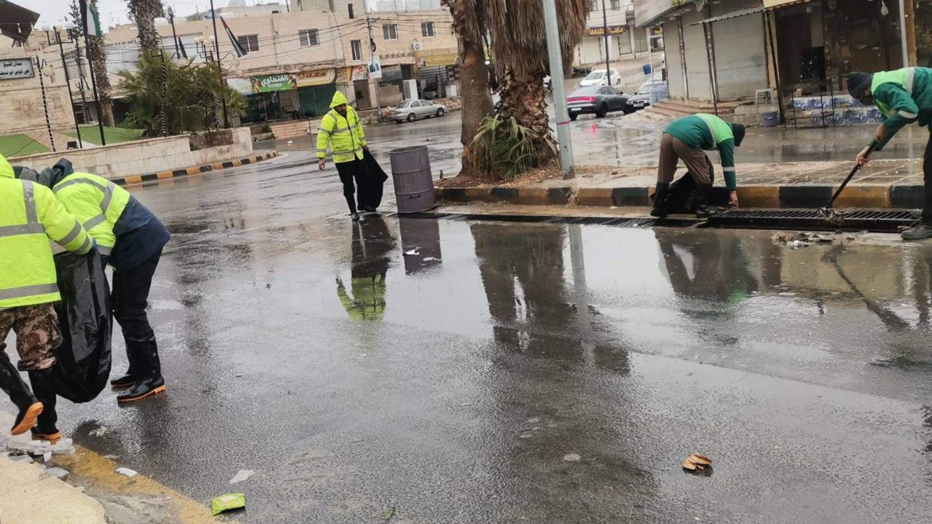 كوادر وزارة الادارة المحلية اثناء تعاملهم مع تجمع للأمطار في أحد الشوارع