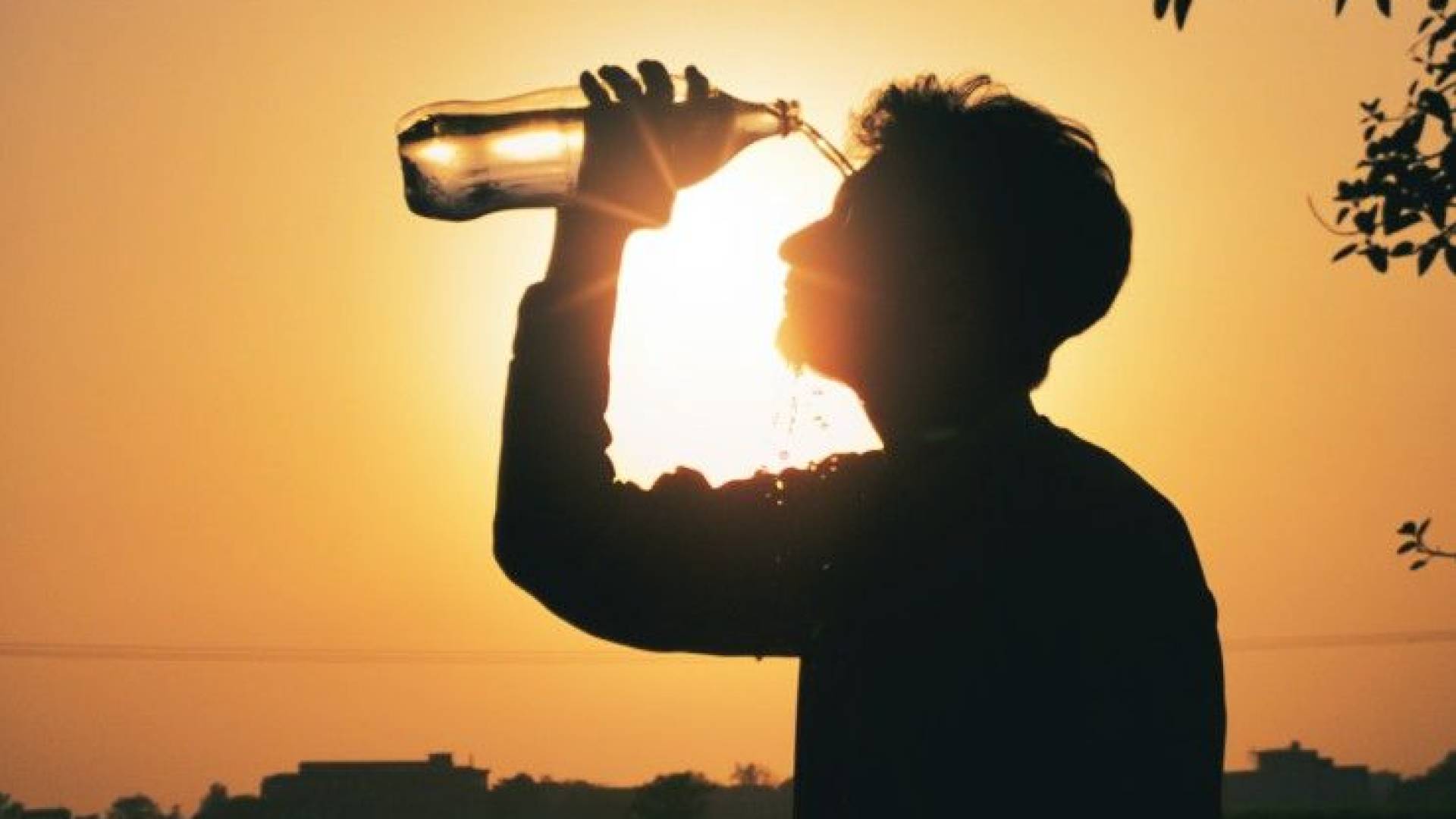 شخص يسكب المياه على وجهه من شدة الحرارة