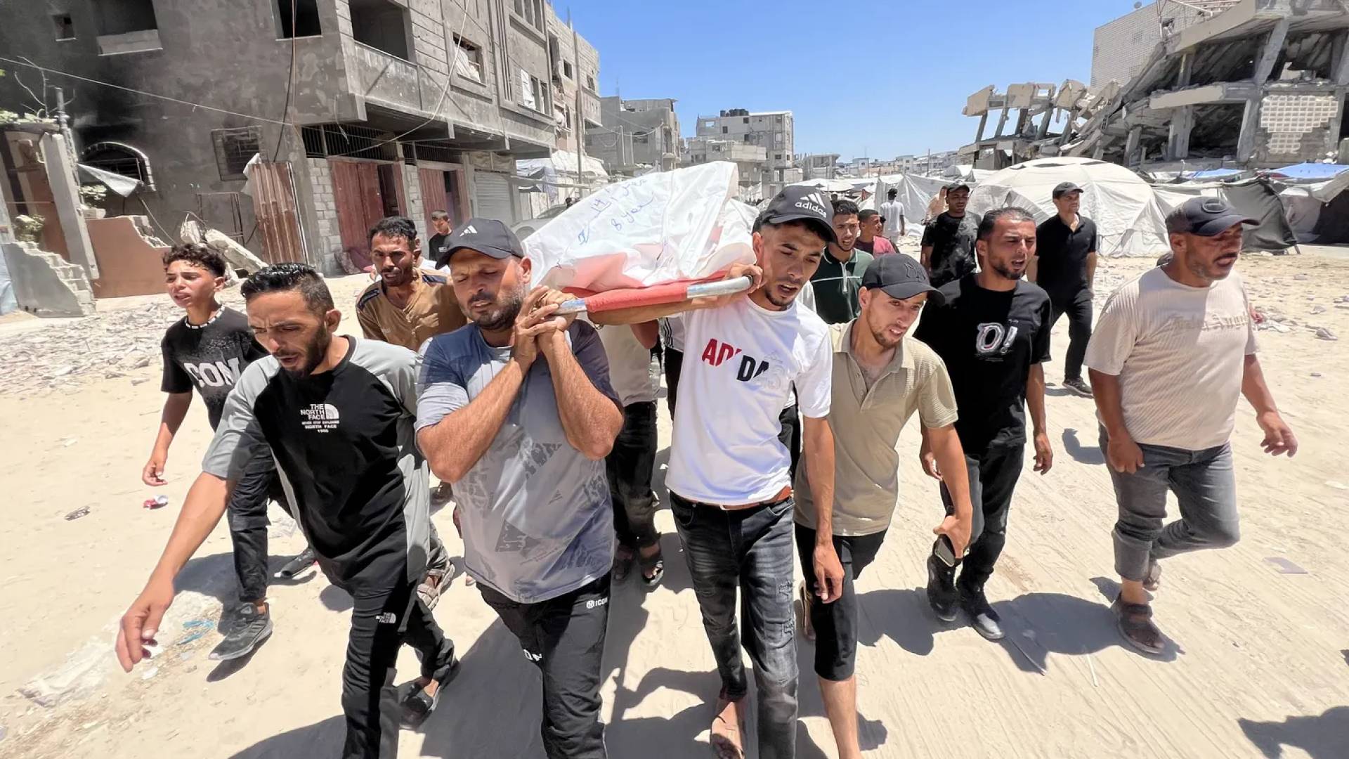 أشخاص يحملون على أكتفاهم جثمان شهيد في قطاع غزة